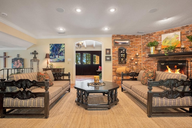 living room featuring ornamental molding, light colored carpet, brick wall, and a brick fireplace