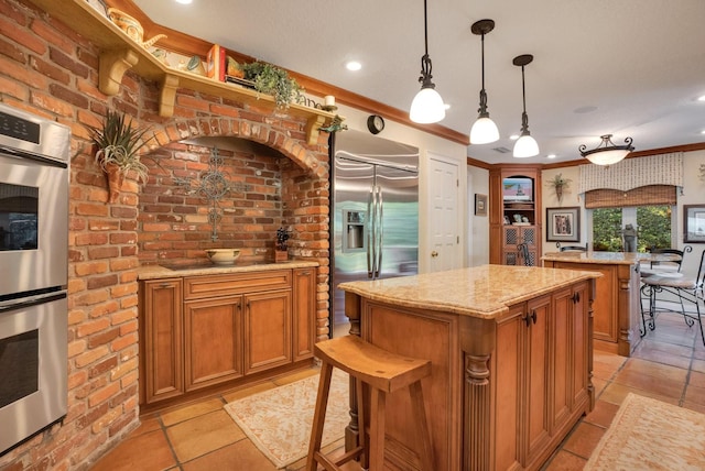 kitchen featuring a center island, stainless steel appliances, pendant lighting, crown molding, and light stone counters