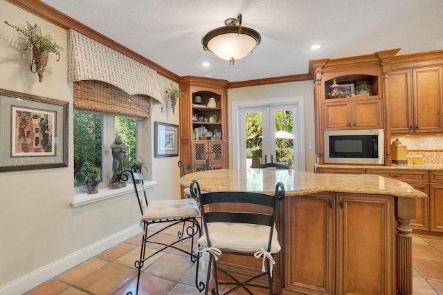 kitchen featuring stainless steel microwave, ornamental molding, light tile patterned flooring, and french doors