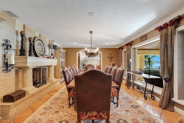 dining space with crown molding, a textured ceiling, and light tile patterned floors