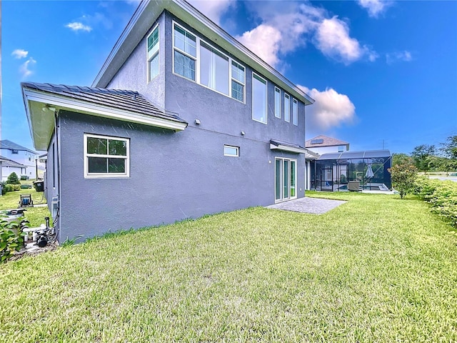 back of house with a yard and a lanai