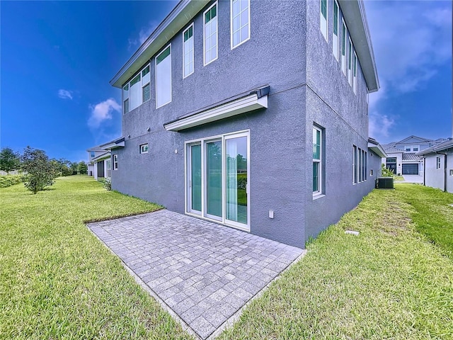 rear view of property with a yard, a patio, and central AC unit