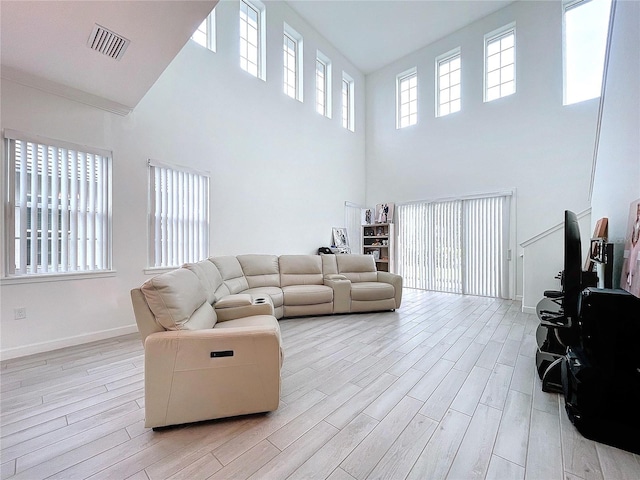 living room featuring light hardwood / wood-style flooring and a high ceiling