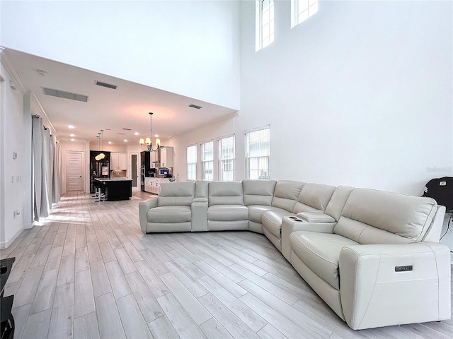 unfurnished living room featuring a notable chandelier and light wood-type flooring