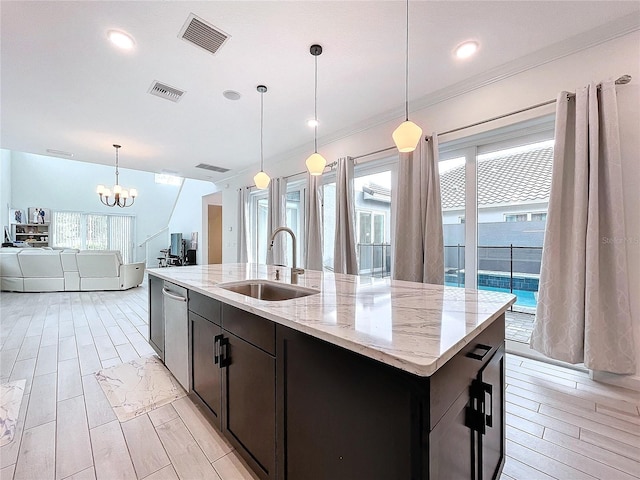 kitchen featuring light hardwood / wood-style flooring, a center island with sink, sink, light stone countertops, and pendant lighting