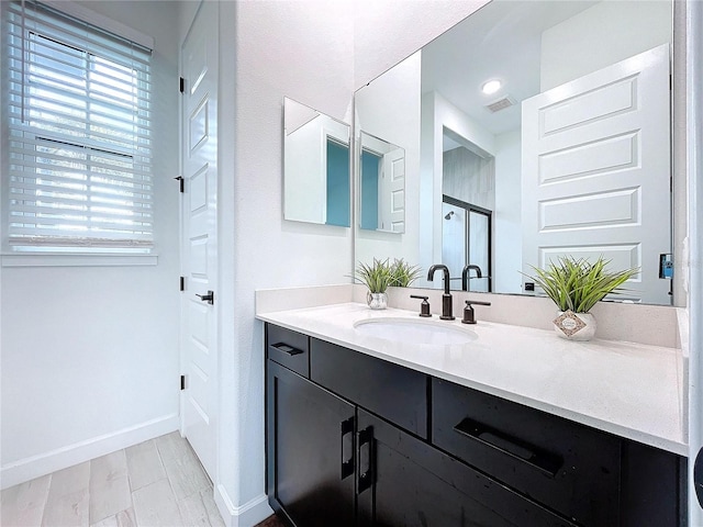 bathroom with a shower with door, vanity, and hardwood / wood-style floors