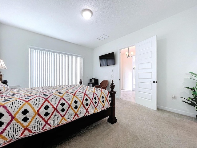 bedroom featuring a textured ceiling and light colored carpet