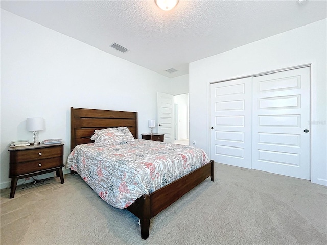 carpeted bedroom with a closet and a textured ceiling