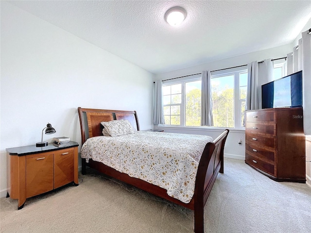 bedroom featuring a textured ceiling and light colored carpet