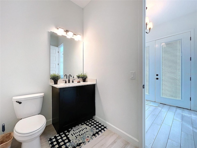 bathroom with vanity, toilet, and wood-type flooring