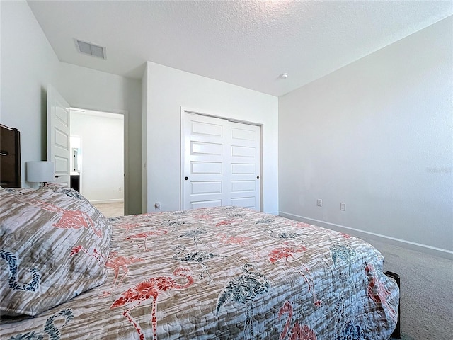 bedroom with a closet, carpet flooring, and a textured ceiling