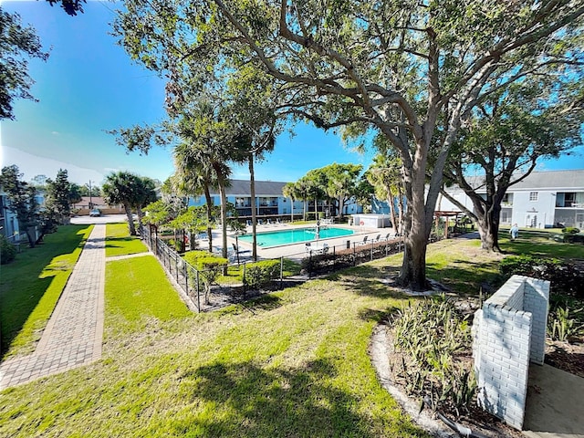 view of property's community featuring a yard and a swimming pool