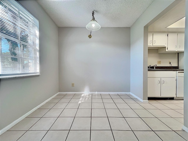 unfurnished dining area with light tile patterned floors and a textured ceiling