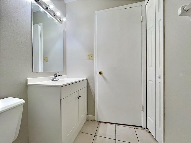 bathroom with tile patterned flooring, vanity, and toilet