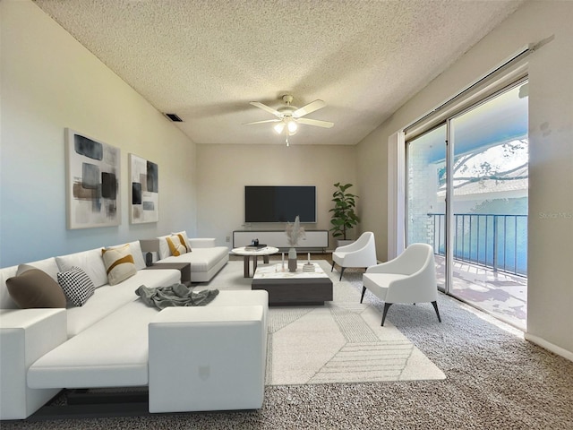 living room featuring carpet, a textured ceiling, and ceiling fan