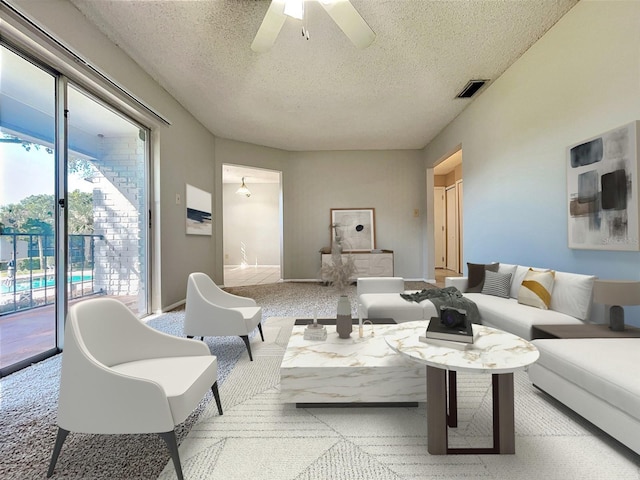 carpeted living room with a textured ceiling and ceiling fan