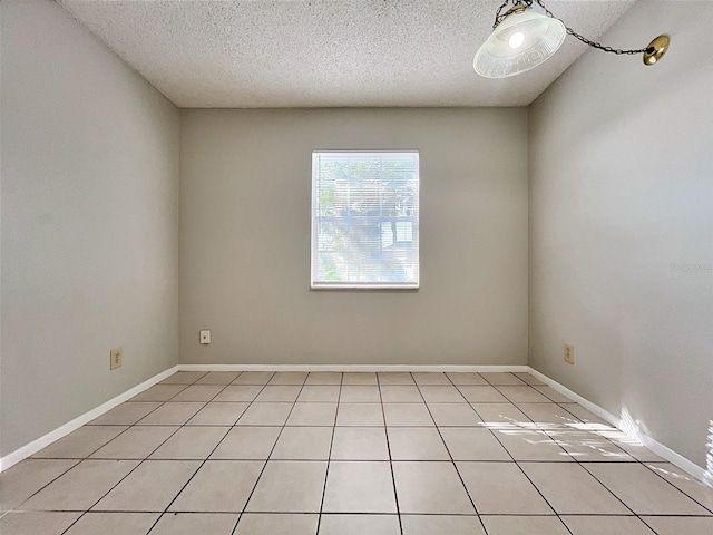 tiled spare room with a textured ceiling