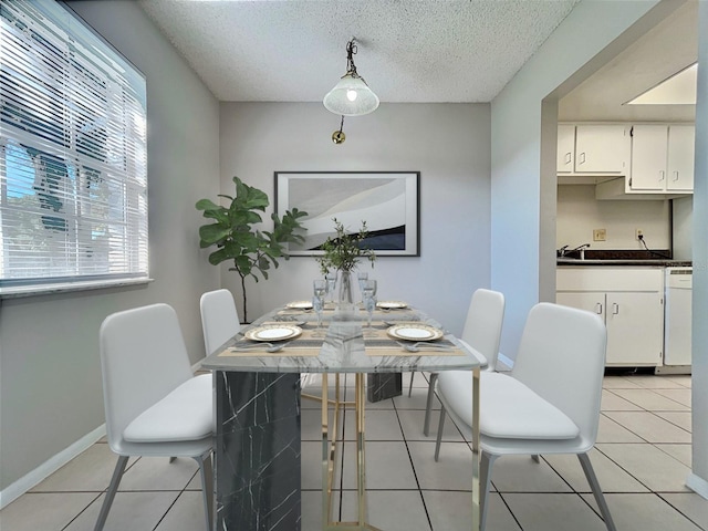 tiled dining space featuring a healthy amount of sunlight and a textured ceiling