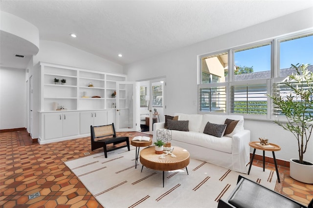 tiled living room featuring a textured ceiling and lofted ceiling