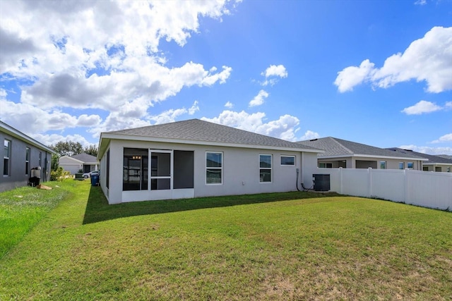 back of property featuring a yard, a sunroom, and central air condition unit