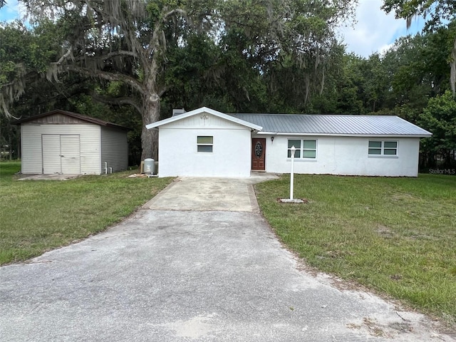 ranch-style home with a front yard and a storage unit