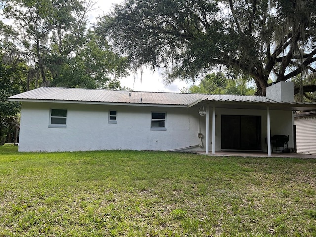 back of property featuring a patio and a lawn