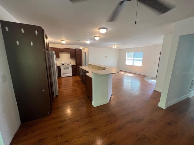 kitchen with a kitchen island, dark brown cabinetry, dark hardwood / wood-style floors, and white appliances