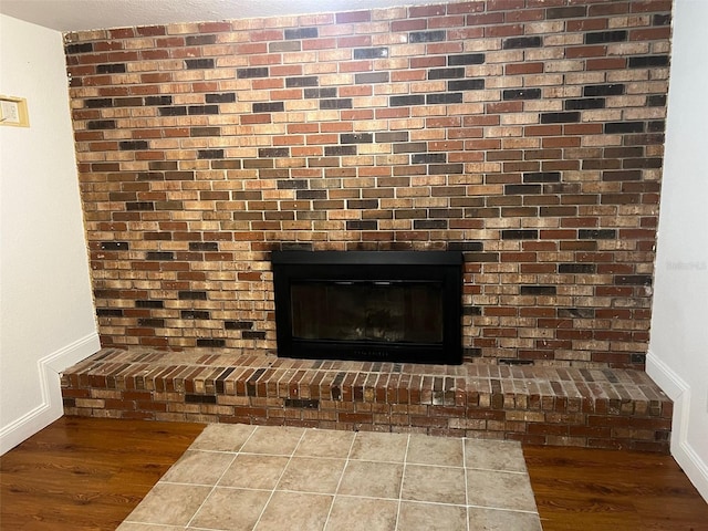 details with hardwood / wood-style flooring and a brick fireplace