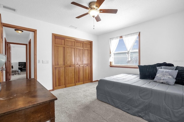 bedroom featuring carpet floors, a textured ceiling, and ceiling fan