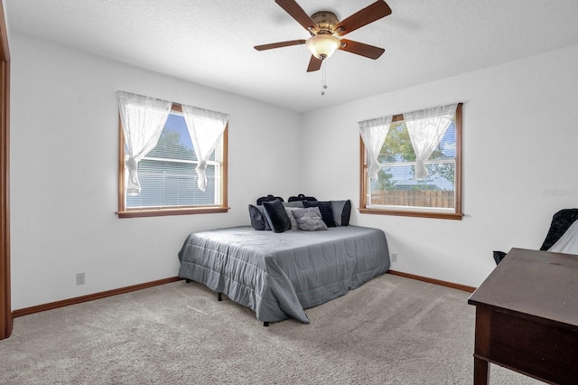 carpeted bedroom with a textured ceiling and ceiling fan