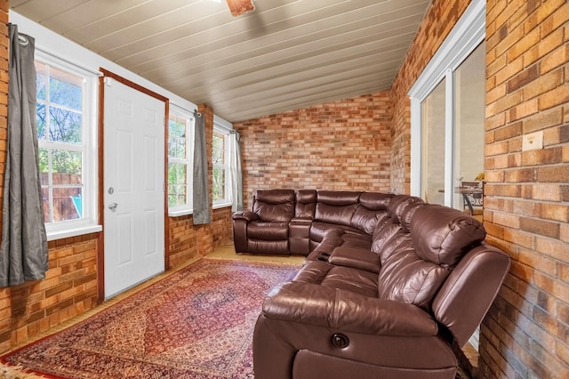 living room with lofted ceiling, wooden ceiling, and brick wall