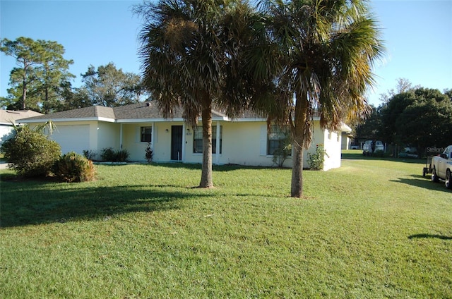 view of front of property featuring a front yard and a garage