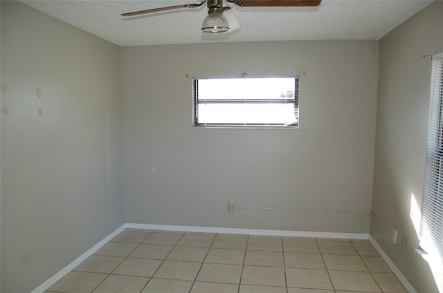 empty room featuring ceiling fan, a textured ceiling, and light tile patterned flooring