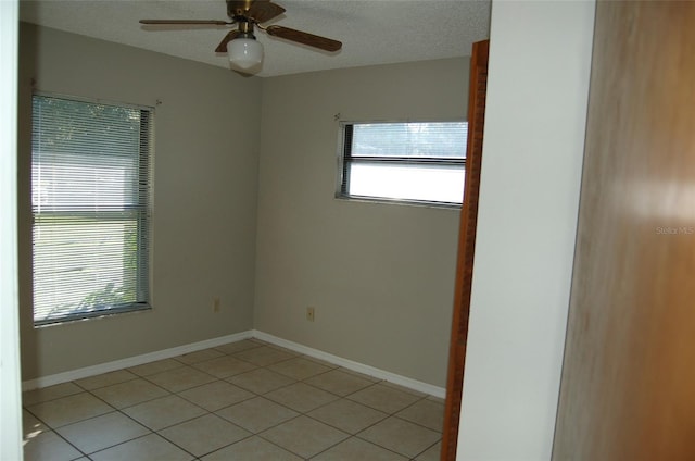 tiled empty room with a textured ceiling and ceiling fan