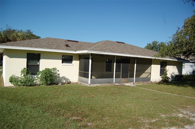 back of property featuring a yard and a sunroom