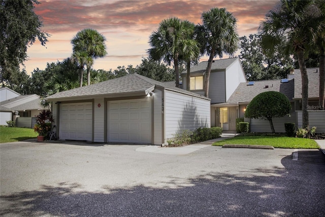 view of front facade featuring a garage and a shingled roof