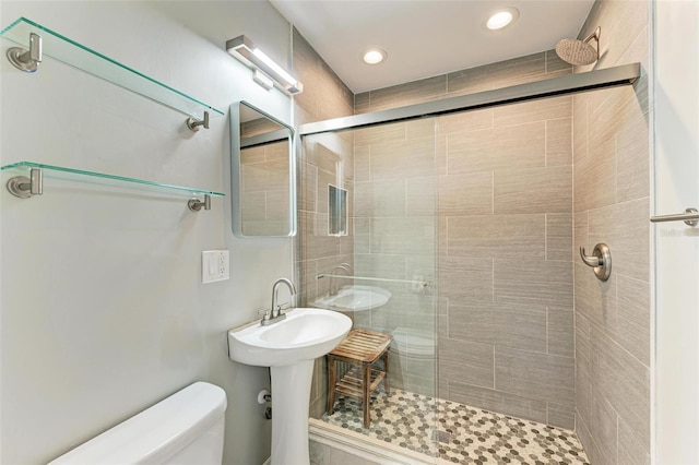 bathroom featuring toilet and a shower with shower door