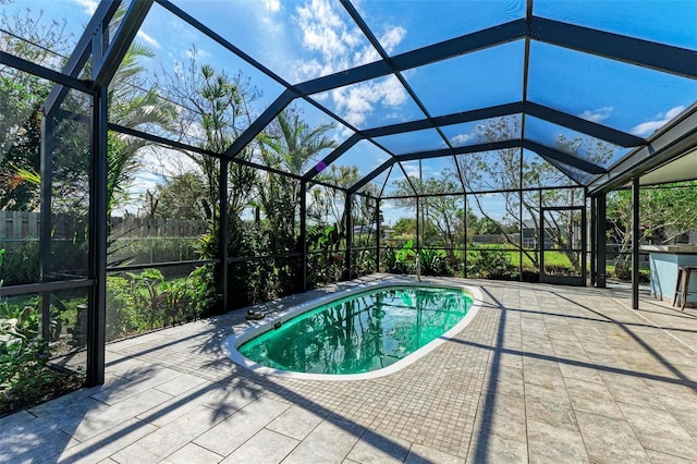 view of swimming pool featuring a patio and glass enclosure