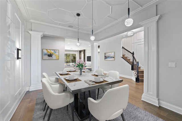 dining area with ornate columns, crown molding, and dark hardwood / wood-style floors