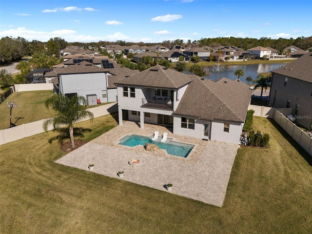 view of swimming pool featuring a water view, a lawn, and a patio area