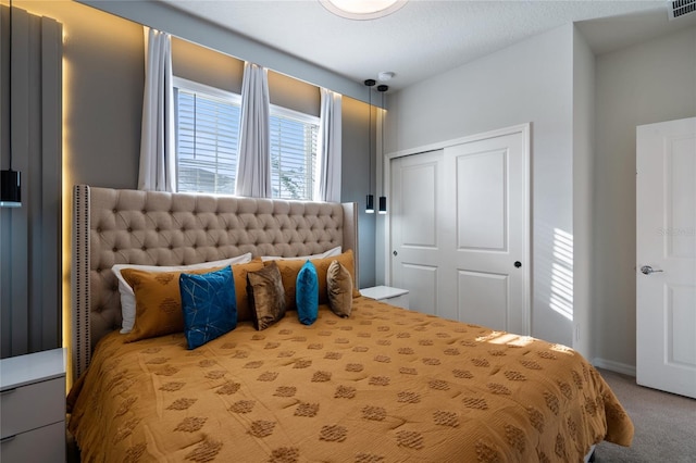 carpeted bedroom with a textured ceiling and a closet