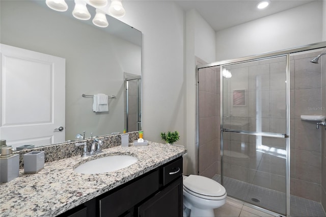 bathroom featuring vanity, tile patterned flooring, toilet, and walk in shower