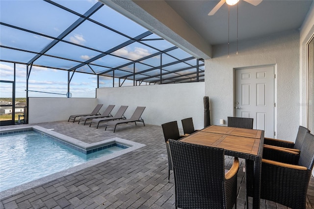 view of swimming pool with ceiling fan, a lanai, and a patio area