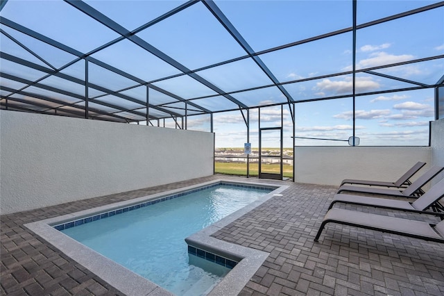 view of swimming pool with a patio and glass enclosure