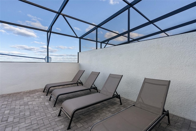 view of patio featuring glass enclosure