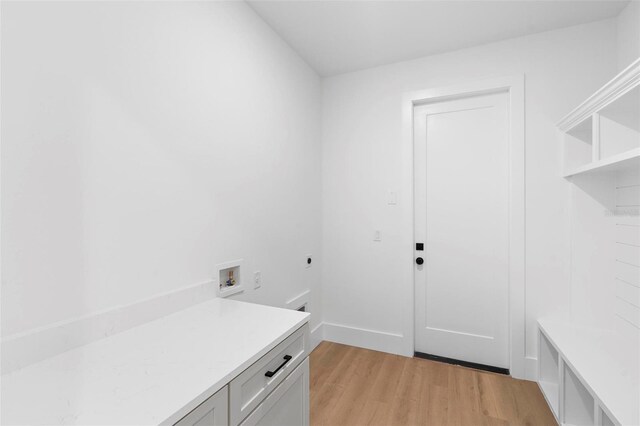 4190 Rossmore Dr, Orlando, FL 32810 - clothes washing area featuring electric dryer hookup, light wood finished floors, washer hookup, and cabinet space
