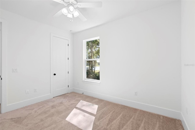 carpeted spare room featuring ceiling fan