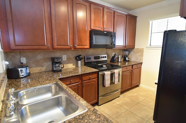 kitchen with dark stone counters, sink, black appliances, light tile patterned flooring, and crown molding