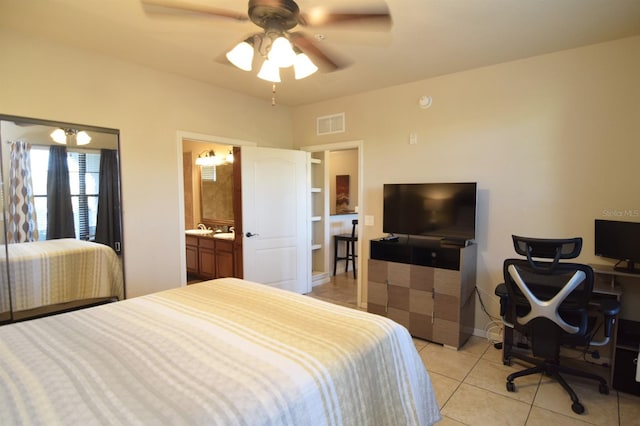 bedroom with ensuite bath, light tile patterned flooring, and ceiling fan