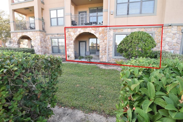 exterior space with a balcony and a front lawn